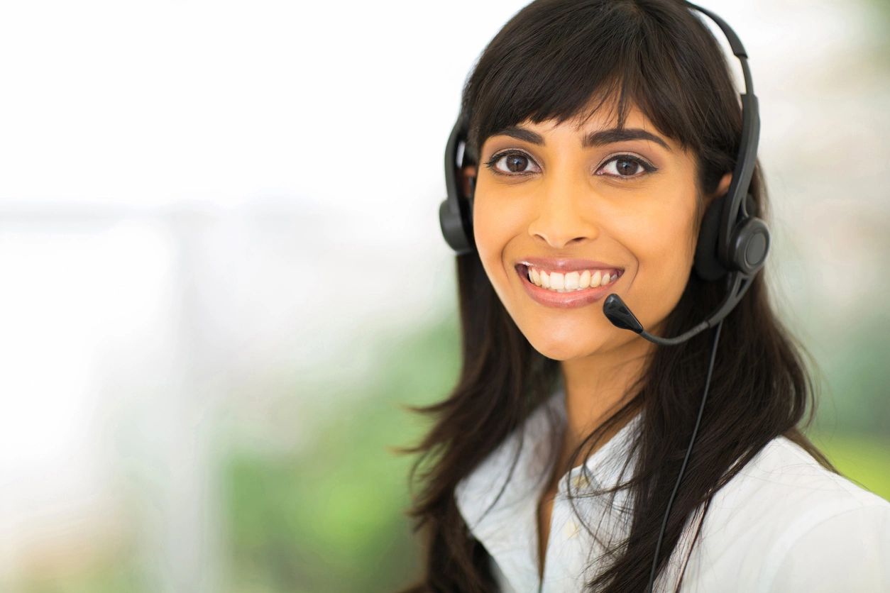 A woman wearing headphones and smiling for the camera.